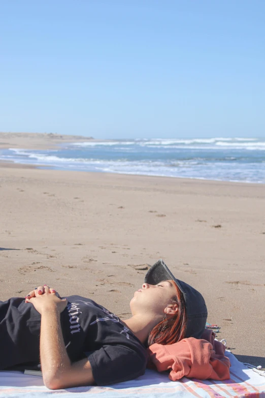 a man laying on the beach and looking at the sky