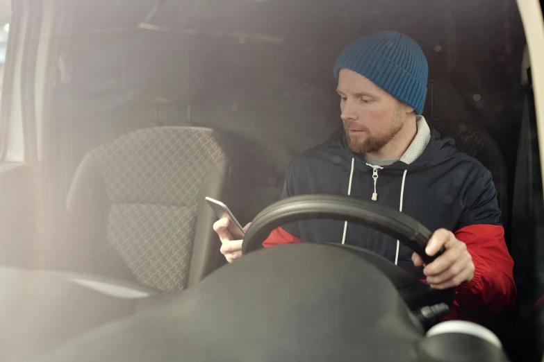 a man driving in his car using his cell phone