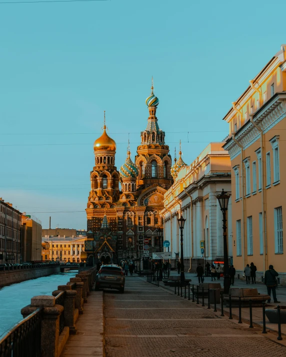 buildings and a street next to water with people walking