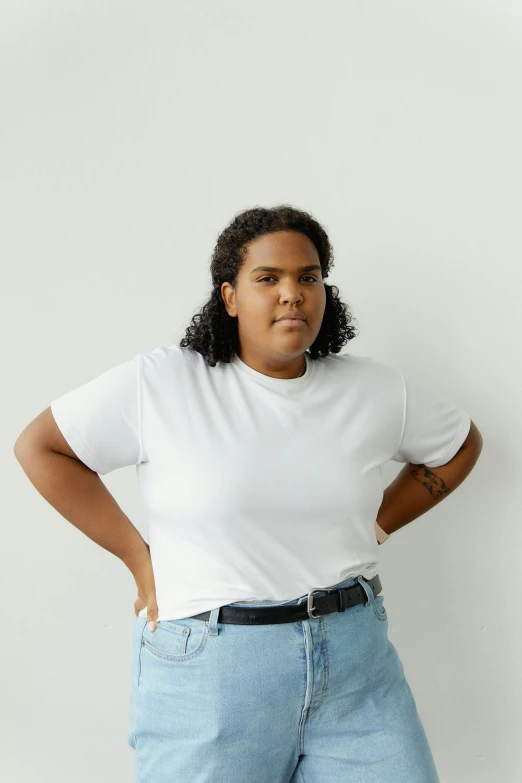 a woman in a white shirt and blue jeans standing up