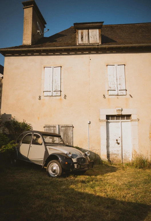 a car is parked in front of an old house