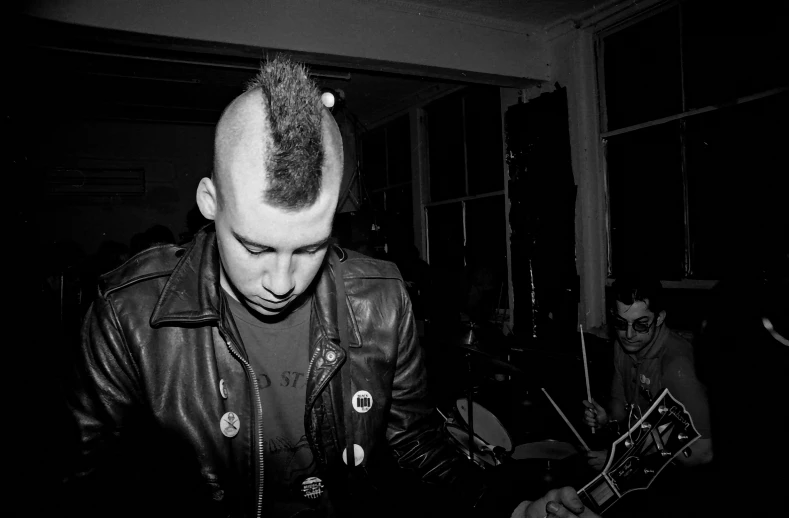 a person with a mohawk playing a guitar