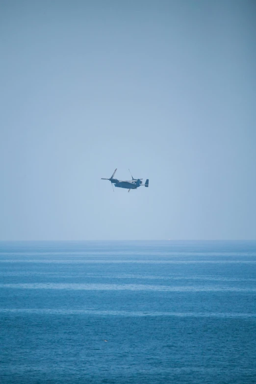 a small airplane flies in front of the ocean