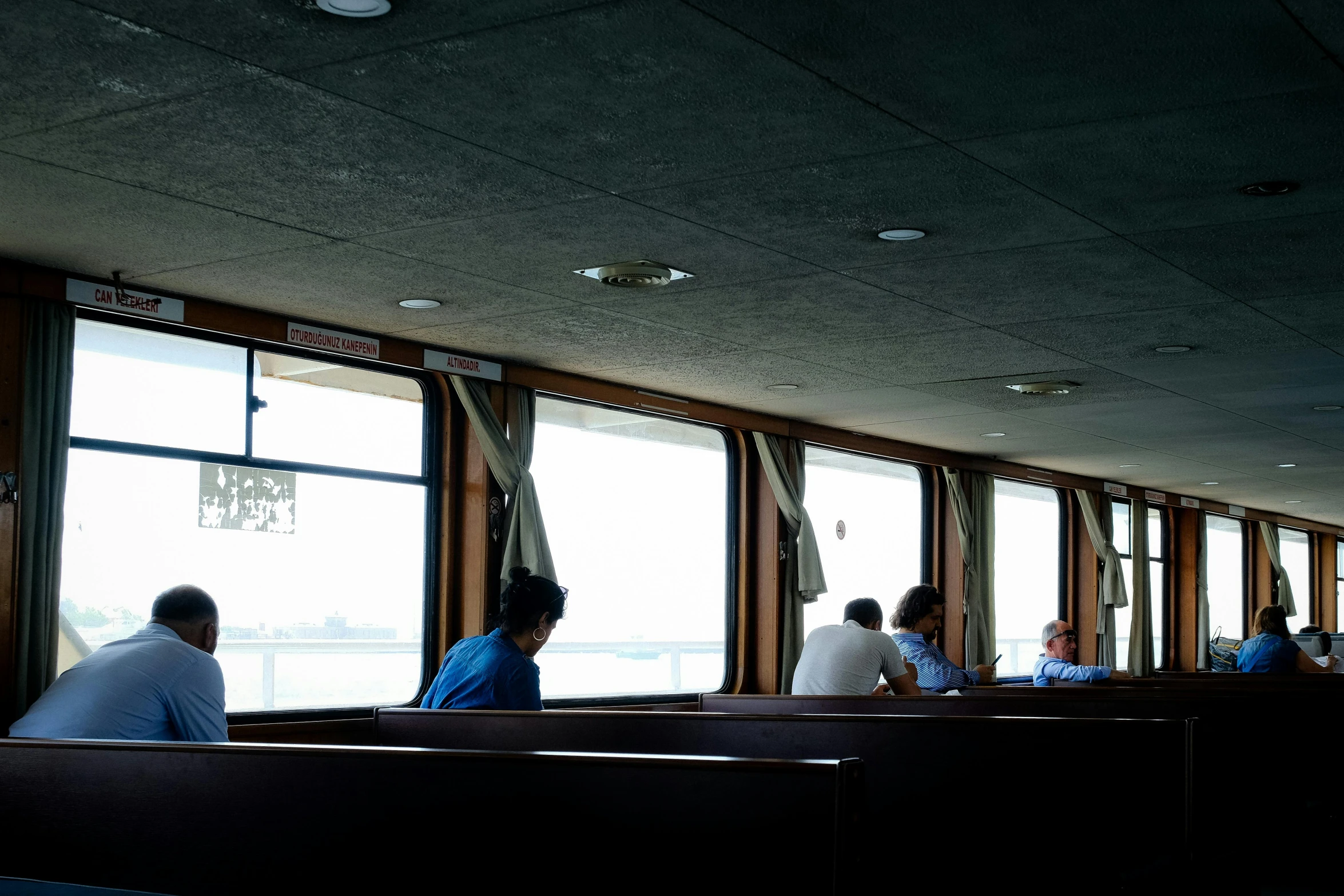 people sit inside a restaurant in front of a large window