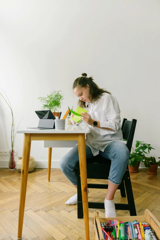 a girl is sitting at the table while she uses her cell phone