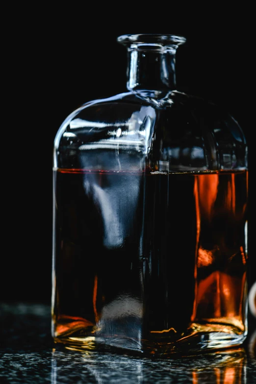 an empty glass bottle filled with liquid sitting on a counter