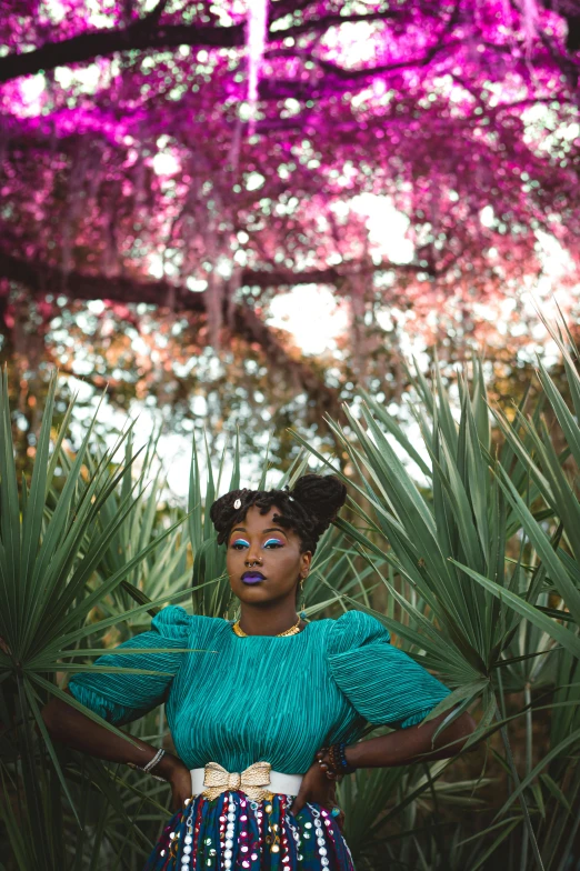 young african american woman in front of the trees with pink flowers