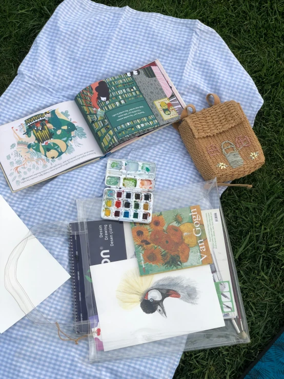 several books are on a bed in the grass