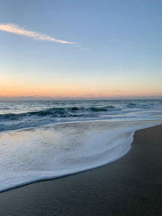 a beach area with waves crashing in towards the shore