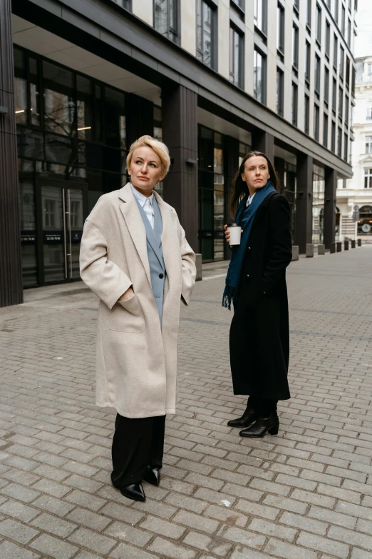 two women standing on the street in coats