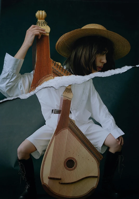 a person holding a guitar and wearing a hat