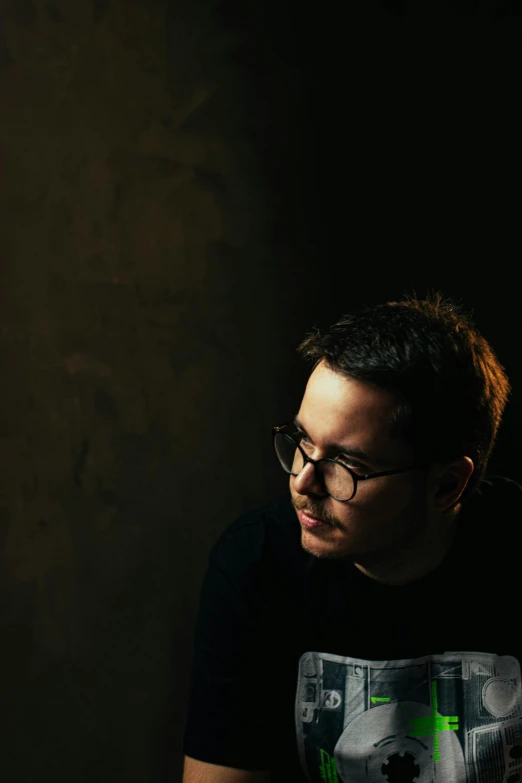 a man wearing a black tshirt while holding a drink in his hand