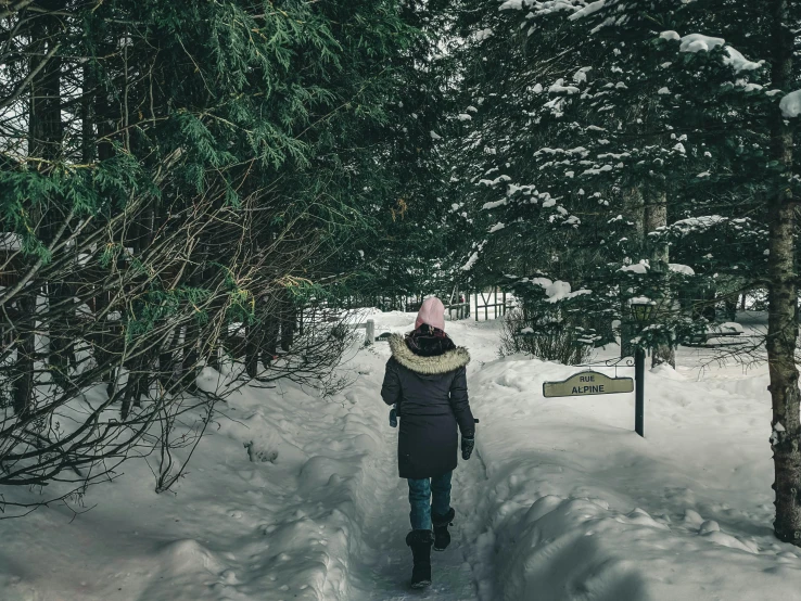 a woman walking down a path on a snow covered path