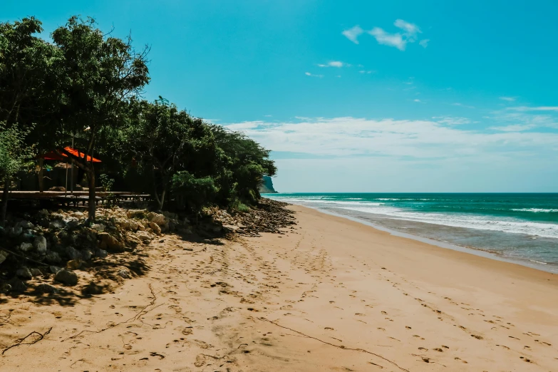 a scenic beach with benches and water under a blue sky