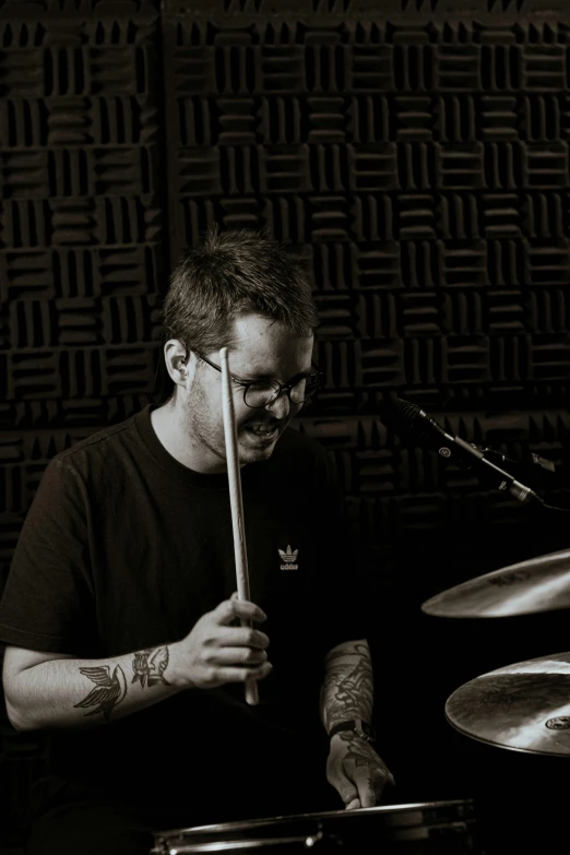 a man playing drums in front of a microphone