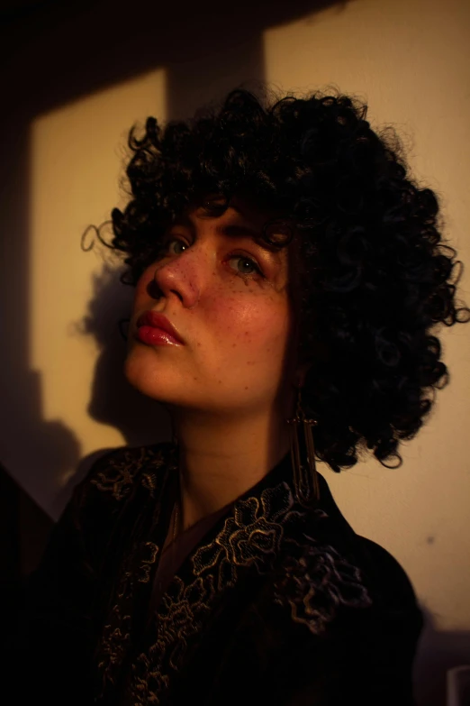 woman with curly hair in the sunlight wearing ear rings