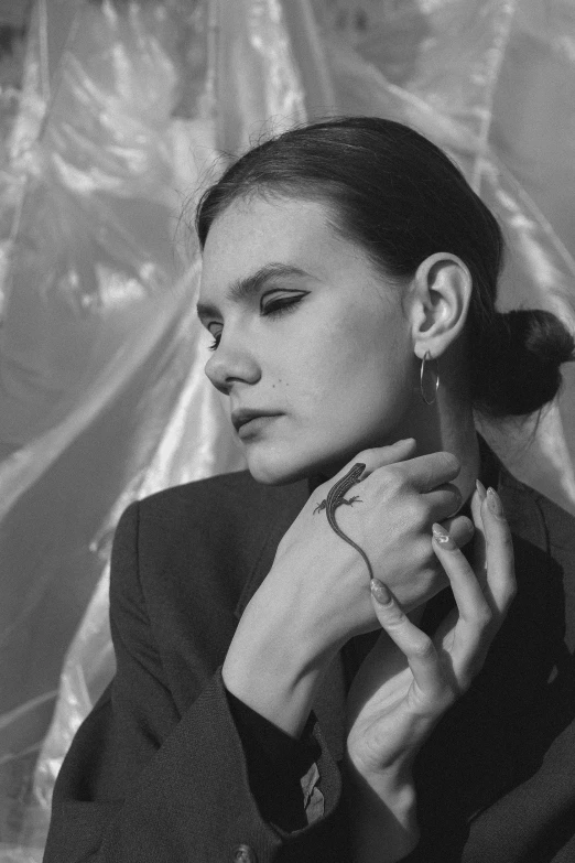 a woman sitting in front of a wall with a ponytail in her hair