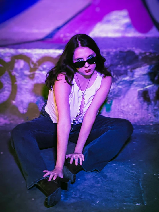 a female in sunglasses sitting on the floor