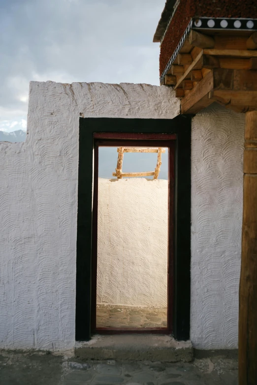 an open door leading into the outside of a white stucco building