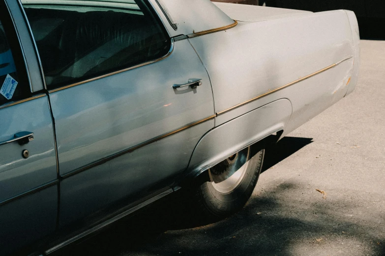 the tail end of an older automobile parked on the side of the street