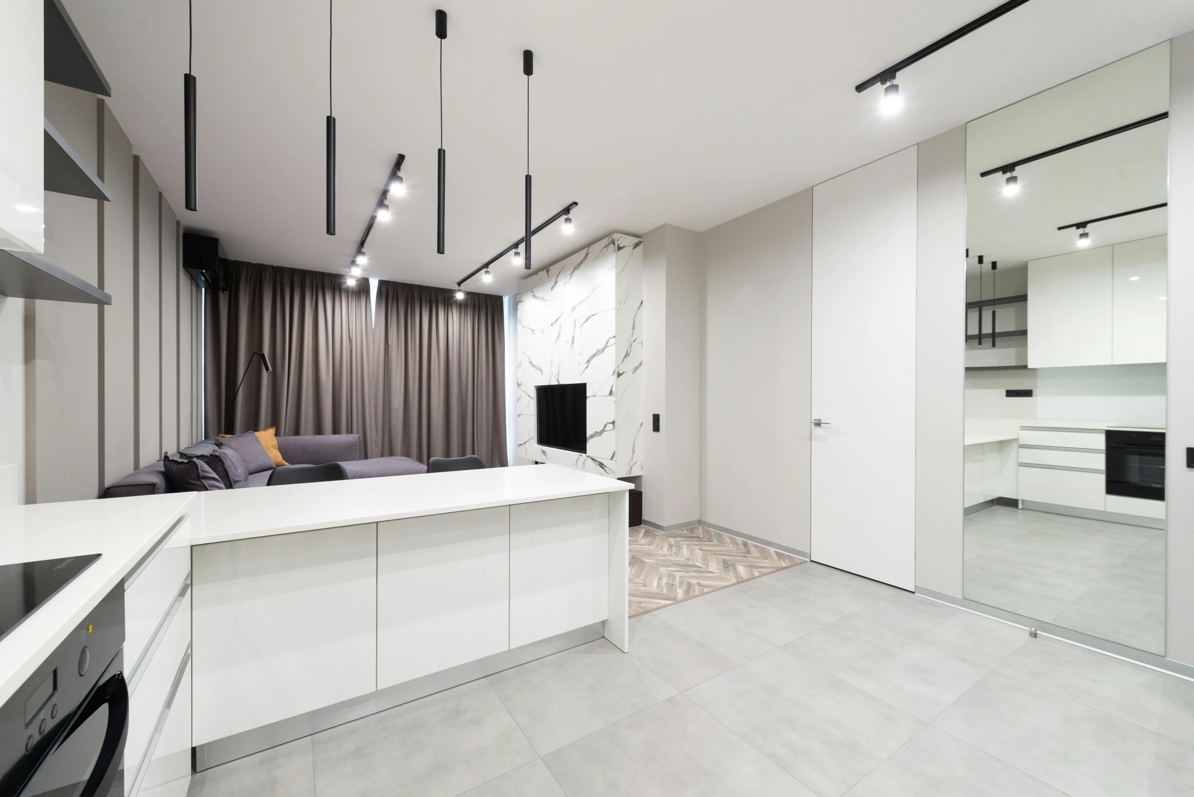 a long counter with some white cabinets and lights