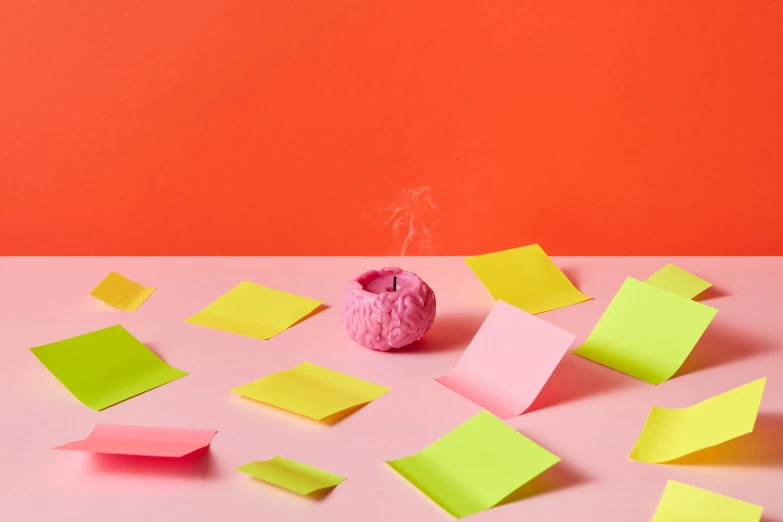 a pink apple is on a table with notes everywhere