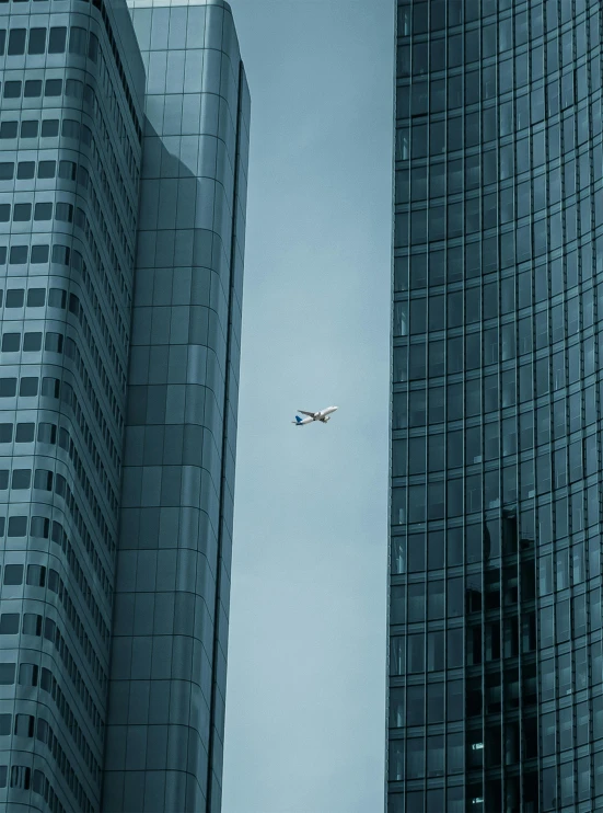 an airplane flying above two tall buildings