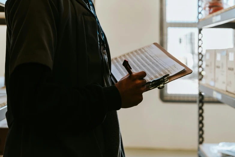 a man holding a clipboard and pen in his hand