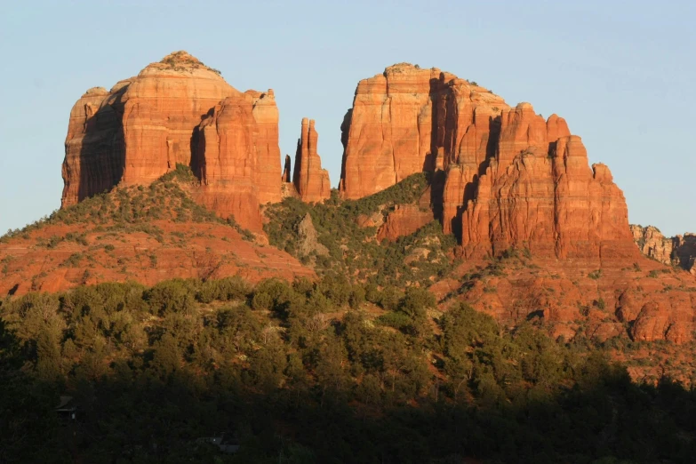 some red rocks and trees against a blue sky