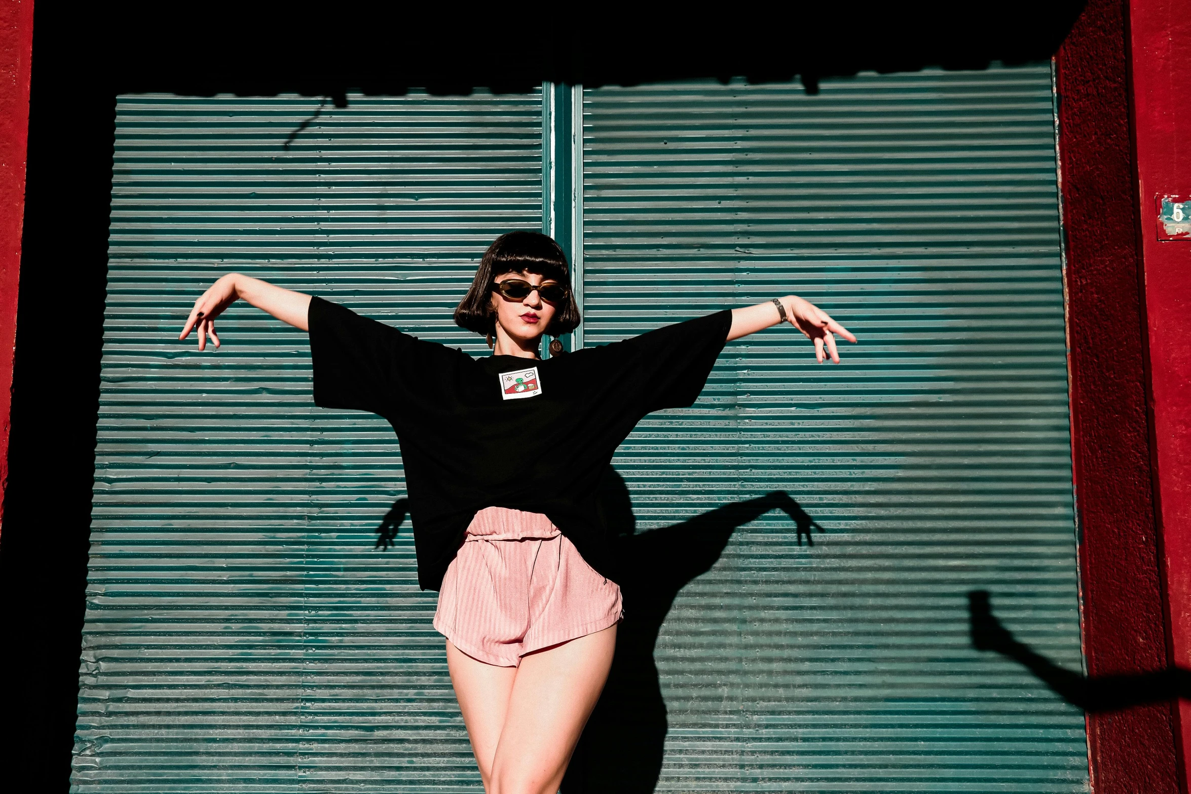 woman standing in front of a closed door with her arms spread out