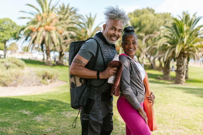 a man standing next to a woman near palm trees