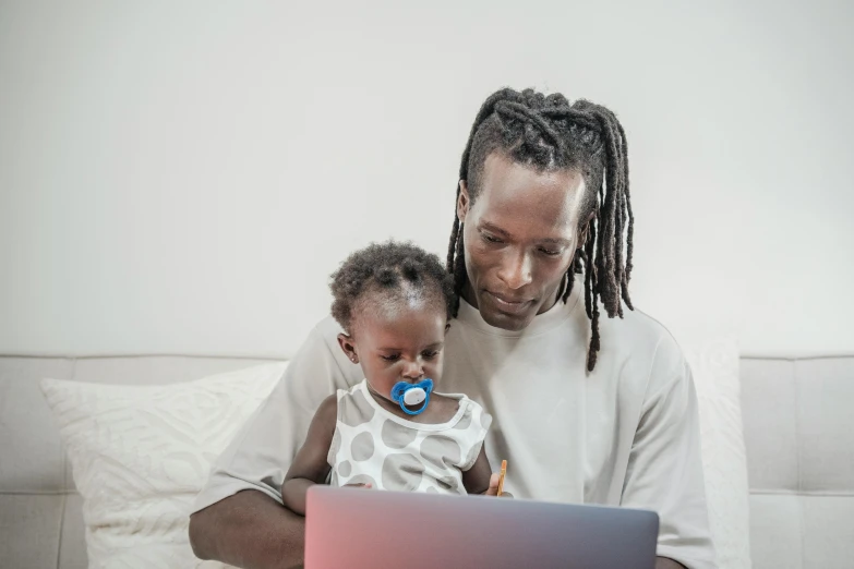 a man and baby look at the computer screen