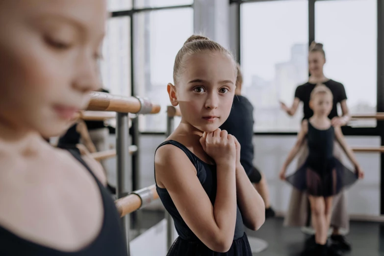 an adult standing in a class with young dancers