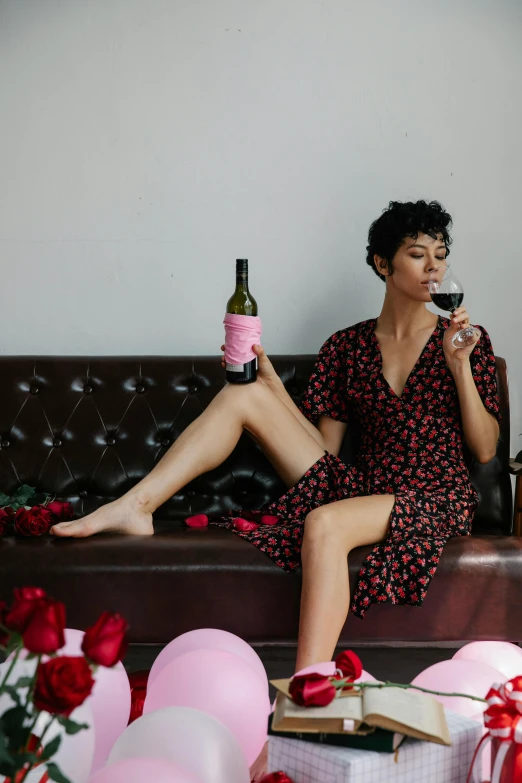 a woman with a wine bottle and a rose in her hand on the couch