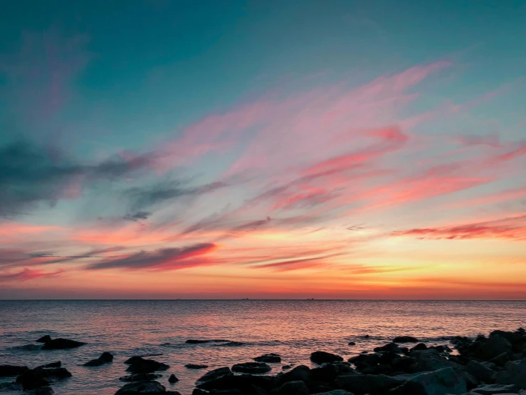 a beach and rocky shore during the sun set