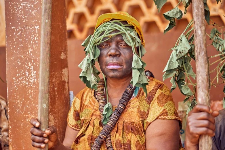 a person in a head dress holding a stick