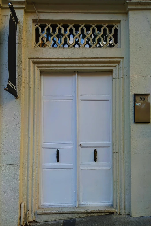two white wooden doors are pictured on an old building