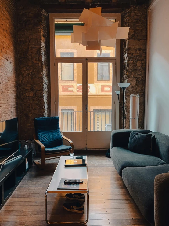 a living room with brick walls, blue furniture and wood floors