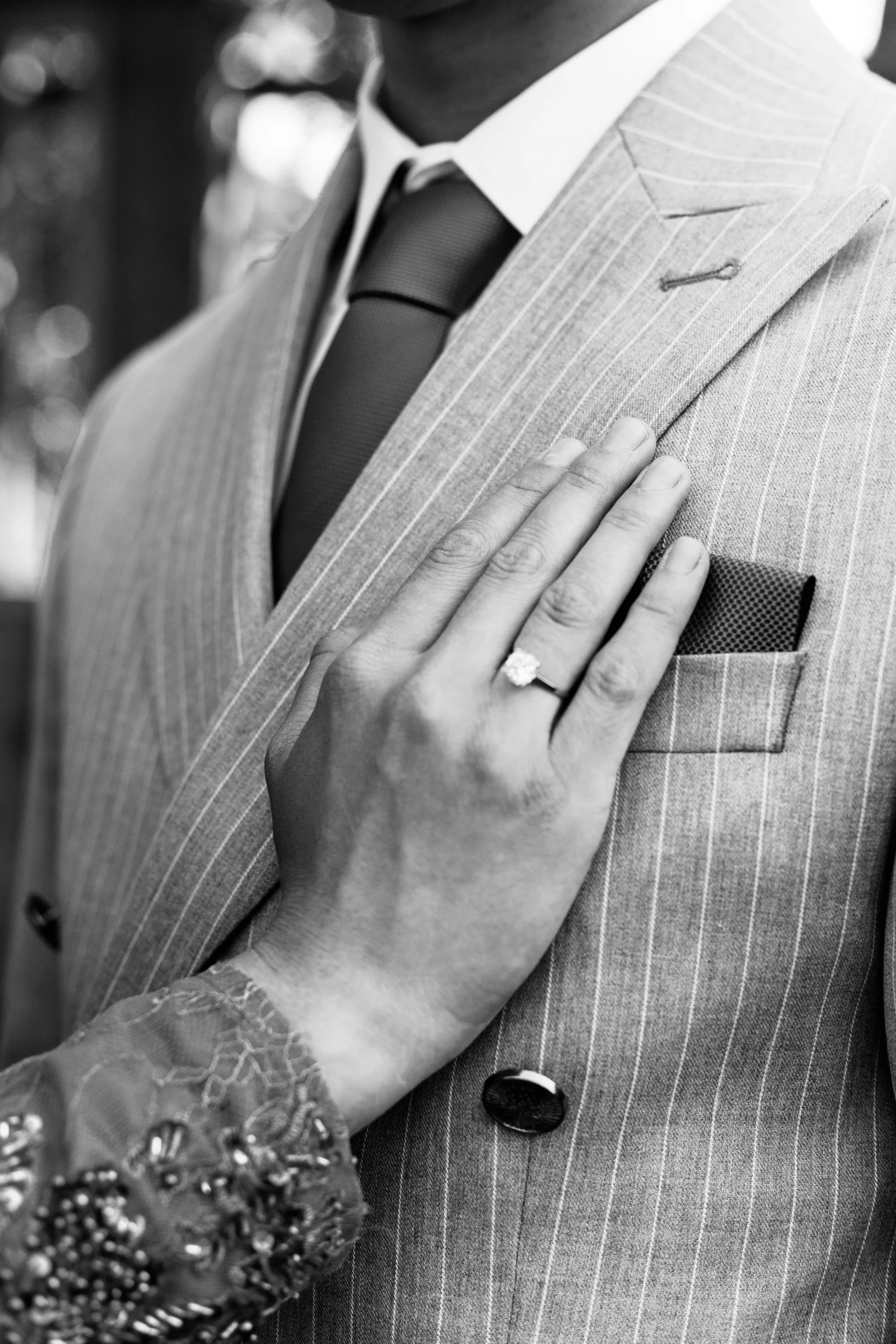 a man in a pinstriped suit holds his hands close together