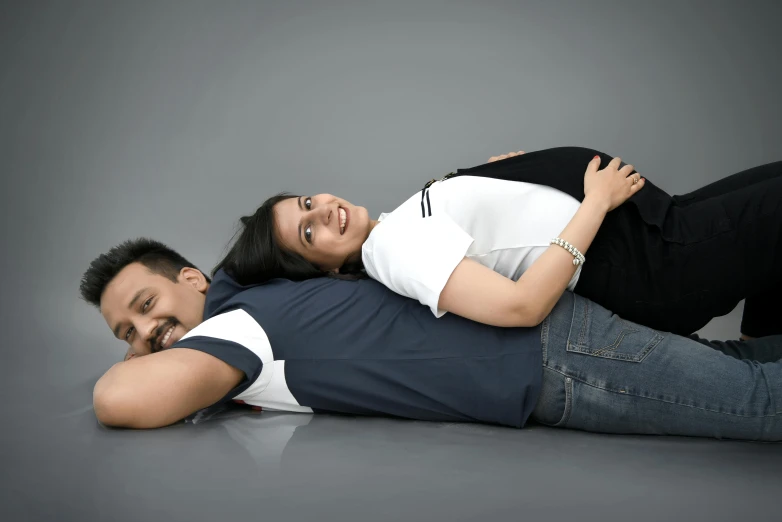 a man and woman laying on the floor hugging