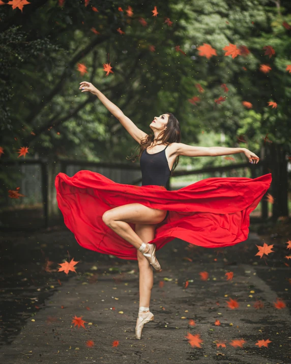 a woman in a black leotard and red cape is holding her arms out