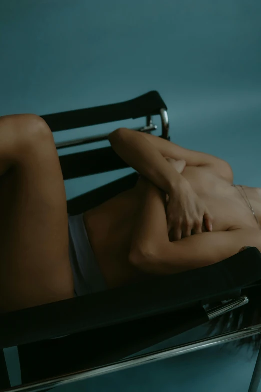 a  woman laying in a chair with her hand on the back