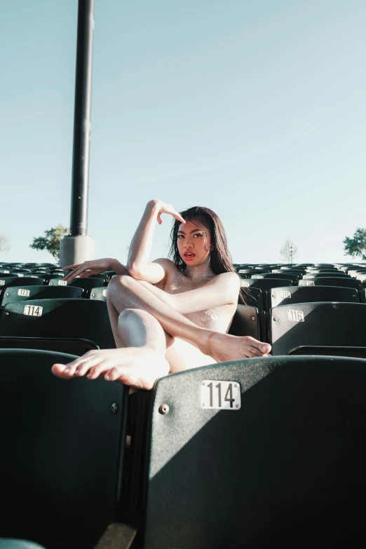 the woman sits inside of a stadium filled with seats