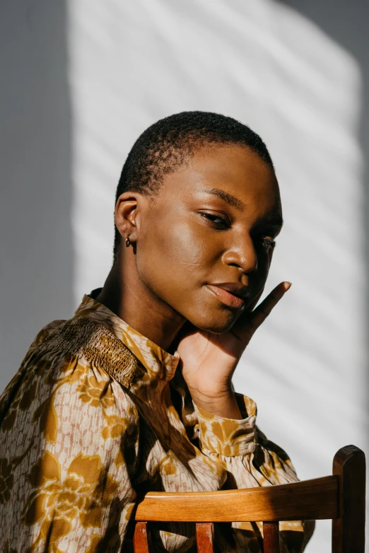 a woman poses with her hands to her mouth while wearing a print shirt