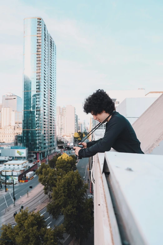 a person is sitting on the ledge overlooking a city