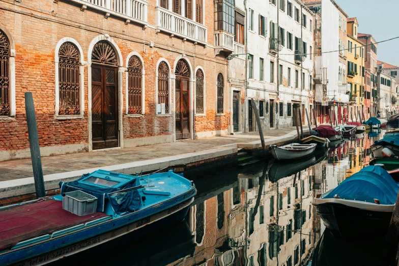 boats docked on the side of a small canal