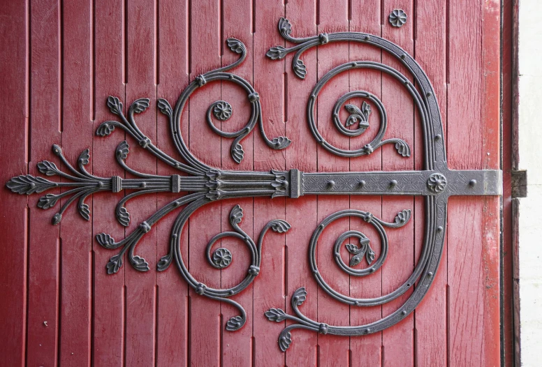 a large metal handle attached to a red wooden door