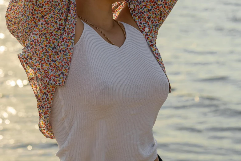 a lady with a colorful umbrella by a body of water