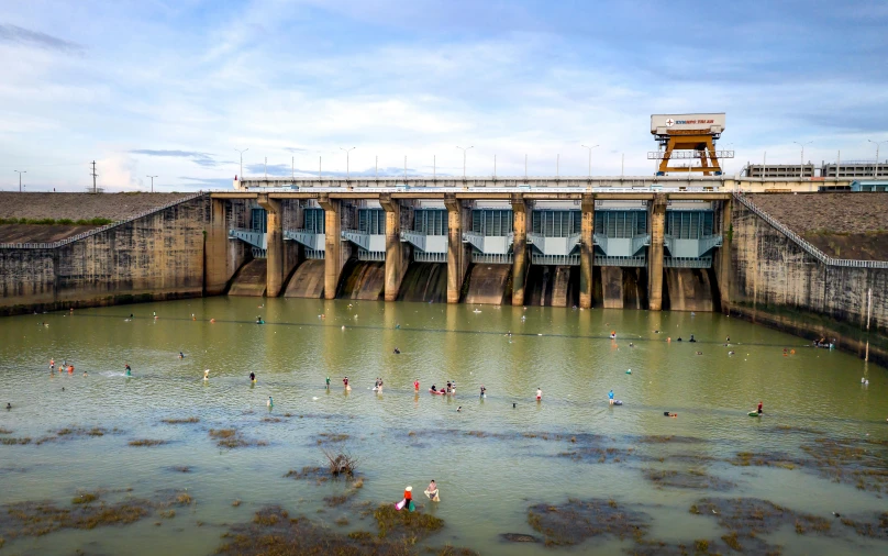 the entrance to a dam with people swimming