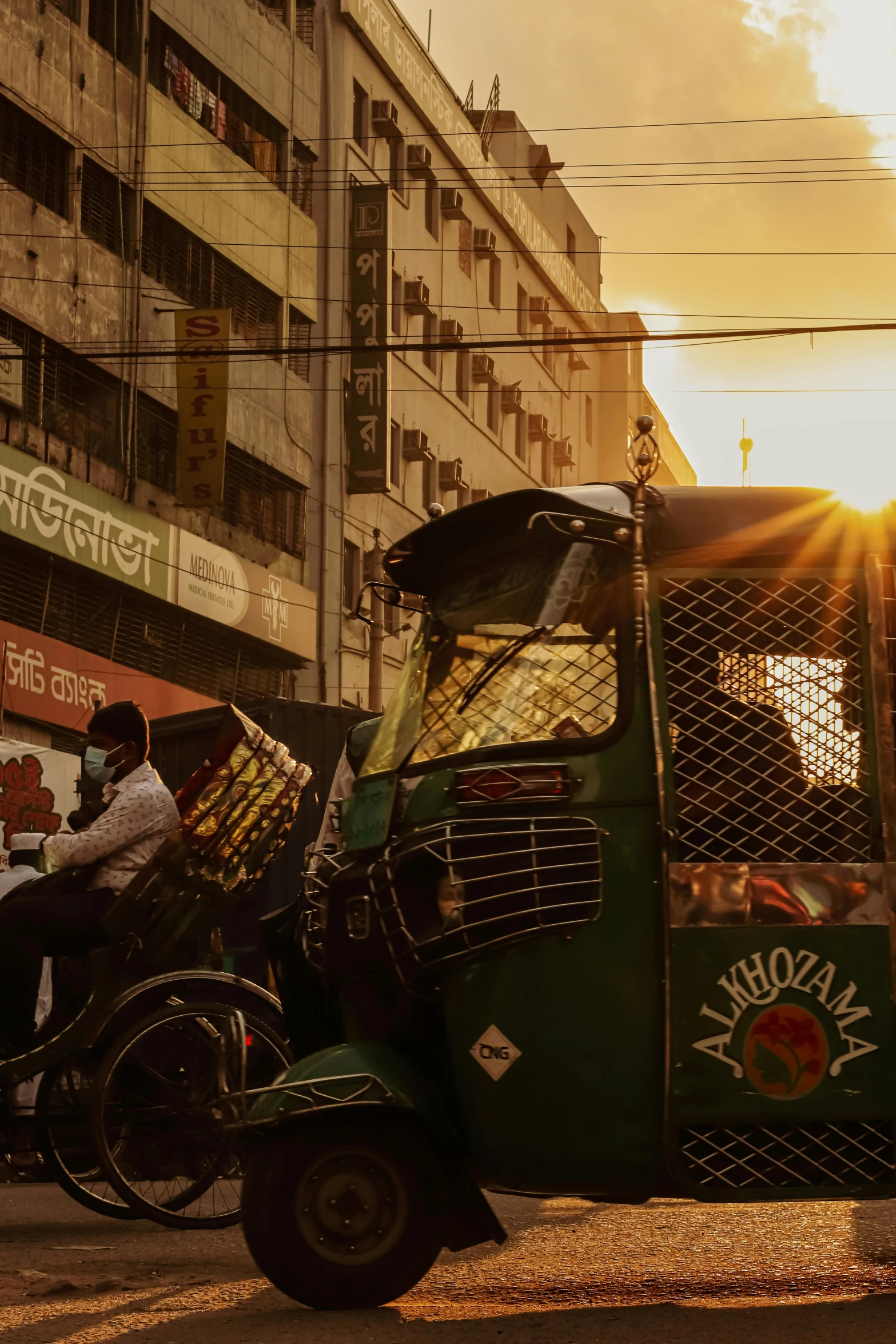 a green semi truck pulling a bike behind it